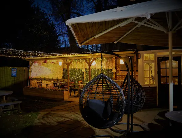 Covered outdoor terrace with fairy lights and a hanging egg chair