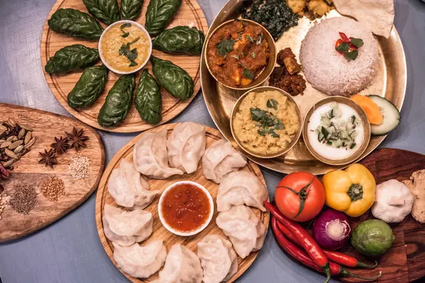 Spread of Nepalese dishes including momo, dal bhat thali and fresh spices