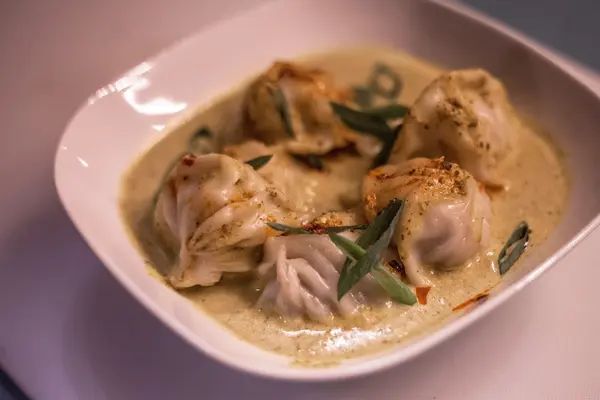 Momo served in a creamy jhol sauce