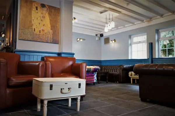 Lounge area with tan leather armchairs and a vintage suitcase coffee table