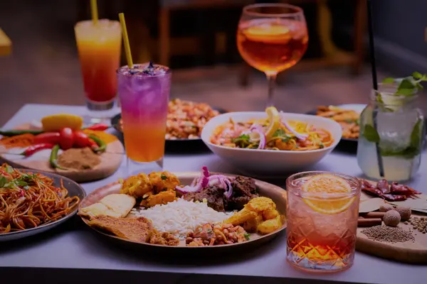Table laid with Nepalese sharing dishes and cocktails