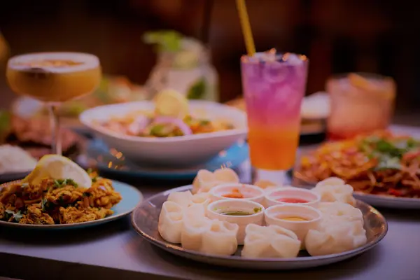 Plate of steamed momo with a selection of chutneys
