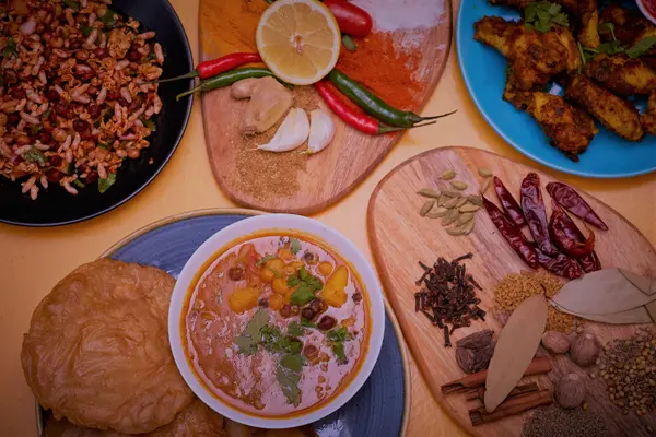 Nepalese sharing spread with curry, puri, chicken wings and whole spices