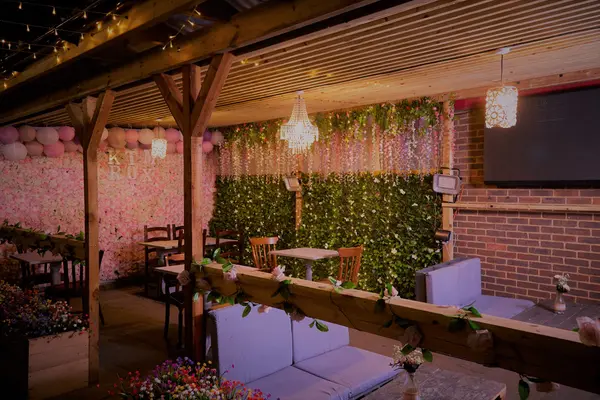 Private hire area with flower wall, pergola, chandeliers and seating