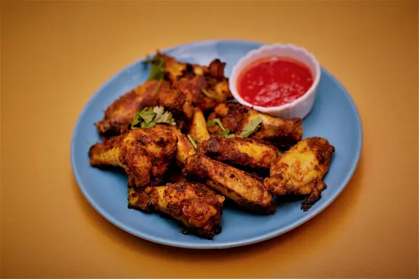 Chicken wings in a house chilli blend with dipping sauce