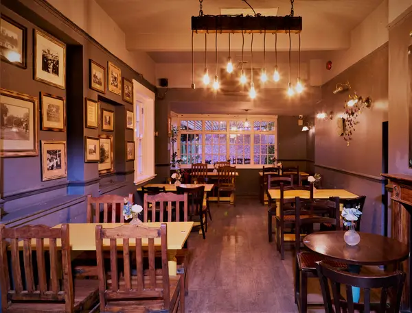 Dining room with wooden tables and an Edison bulb chandelier
