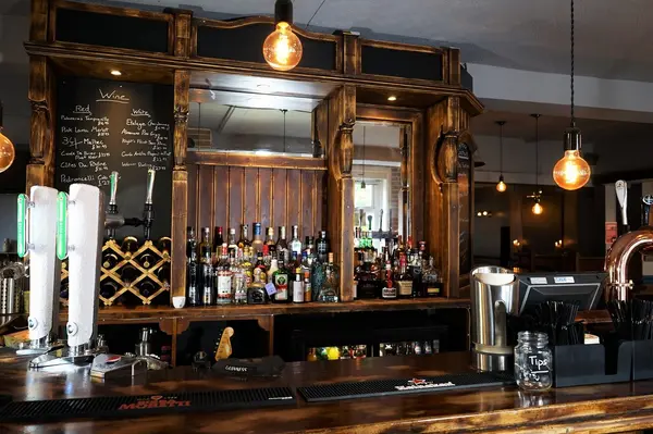 Back bar stocked with spirits, wine chalkboard and draught beer taps